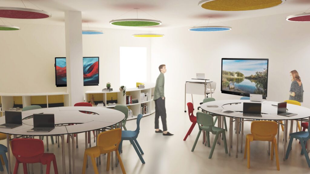 Une salle de classe d'école numérique moderne et lumineuse avec des tables rondes, des chaises colorées, des ordinateurs portables, des étagères, de grands écrans et deux personnes, l'une debout et l'autre marchant. Des lumières circulaires au plafond ajoutent des accents vibrants à la pièce.