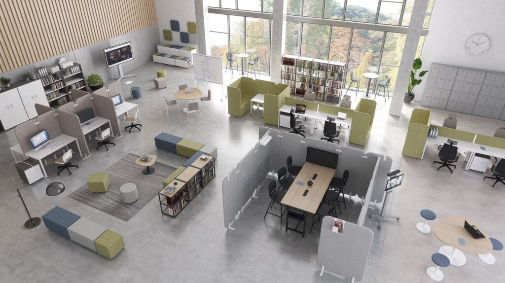 Espace de bureau moderne et ouvert, idéal pour un centro de idiomas ou autoescuelas, comprenant des postes de travail, des étagères, des sièges de salon, de grandes fenêtres avec de la lumière naturelle, des cloisons vertes et grises, une télévision, des casiers, un tableau blanc et des vues sur les arbres à l'extérieur.