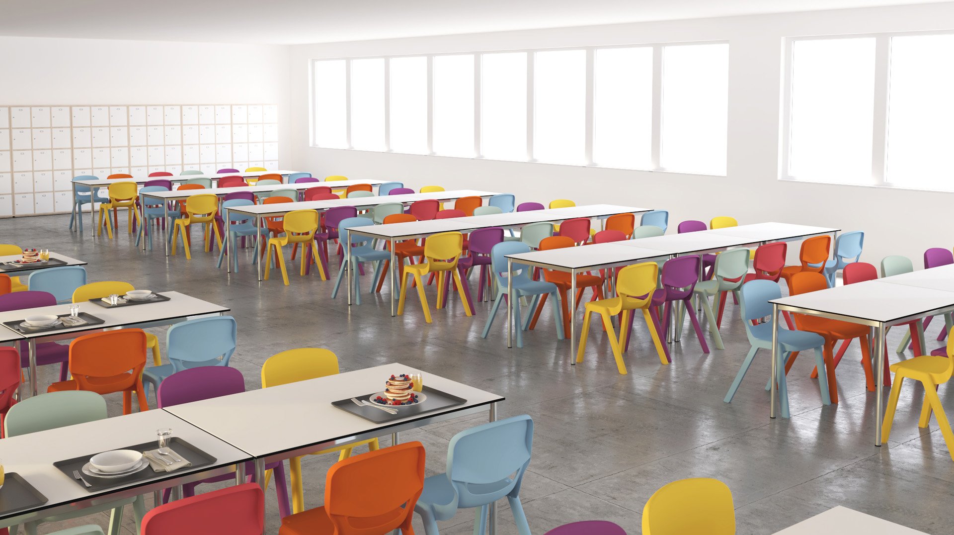Une cafétéria lumineuse avec des tables blanches et des chaises colorées en orange, violet, rouge et jaune. L'espace est bien éclairé par de grandes fenêtres et des casiers bordent le mur du fond. Quelques plateaux contenant de la nourriture et de la vaisselle sont posés sur les tables.