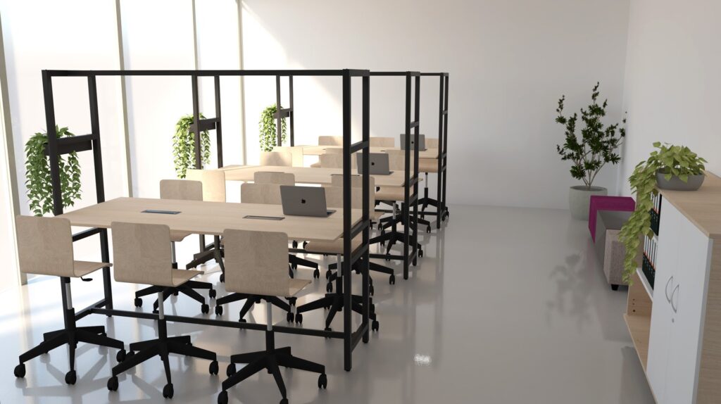Un espace de bureau moderne, rappelant une salle des enseignants, comprend des bureaux partagés en bois, des chaises roulantes, des ordinateurs portables, des plantes en pot à côté des bureaux, une armoire et un coin salon confortable avec un canapé et une table basse entourés d'autres plantes.