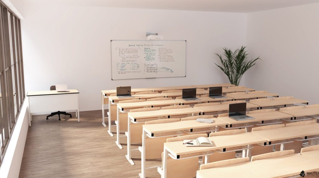 Une salle de classe moderne avec des rangées de bureaux en bois, chacun équipé d'un ordinateur portable. Un livre ouvert est posé sur un bureau. Il y a un bureau de professeur avec un ordinateur portable, une grande fenêtre, un tableau blanc avec des écritures et une grande plante verte dans le coin.