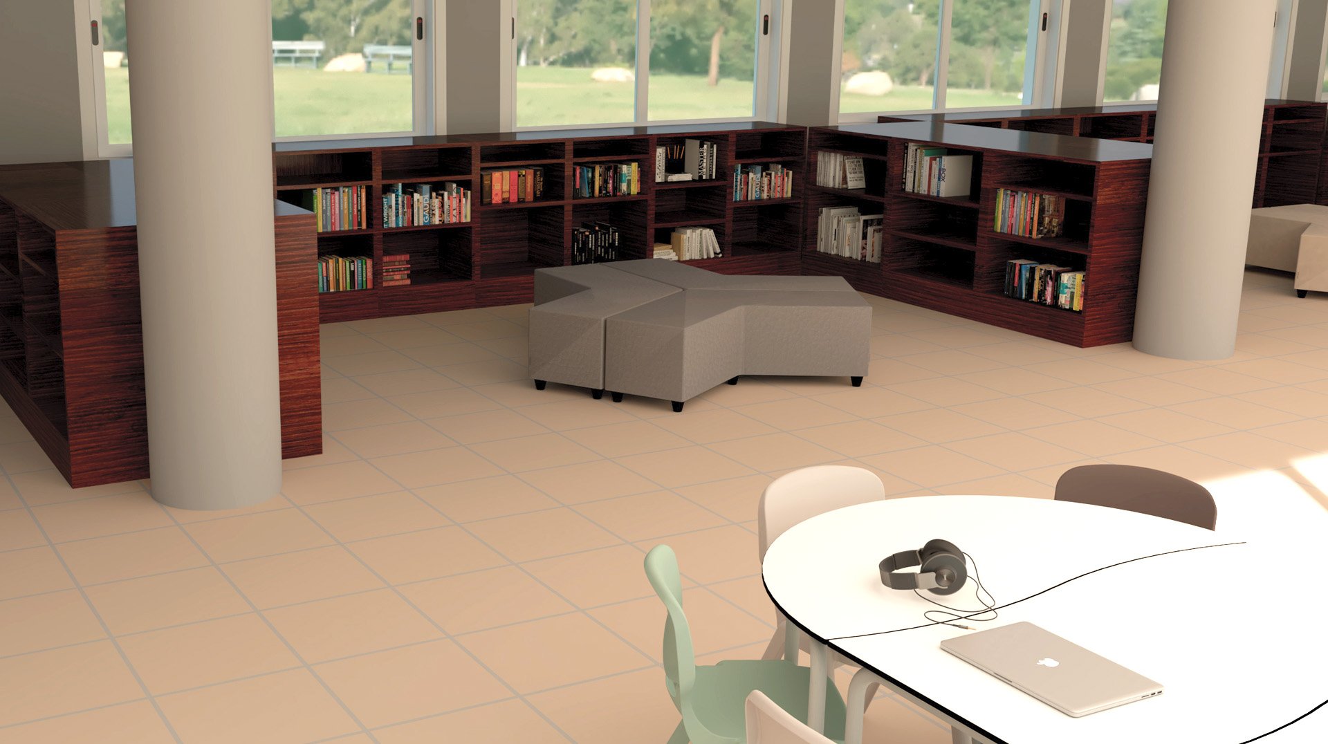 Un espace bibliothèque moderne avec des étagères en bois, des livres, des sièges modulaires gris, une table ronde, des chaises assorties, un ordinateur portable et des écouteurs. De grandes fenêtres révèlent un paysage extérieur verdoyant.