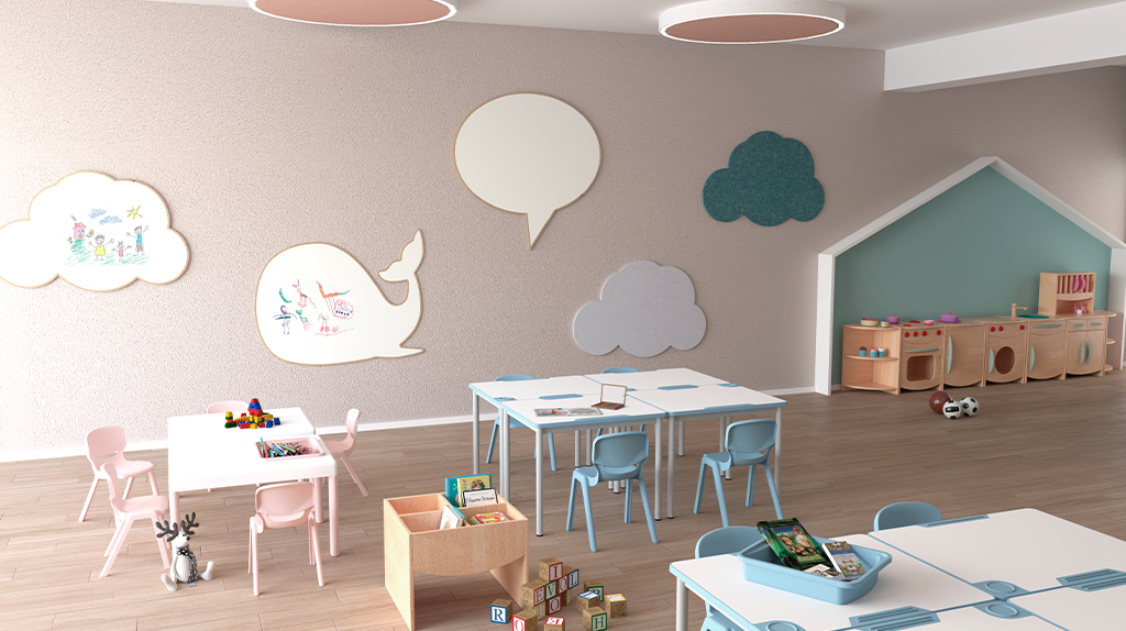 Une salle de classe moderne et lumineuse avec des chaises et des tables aux couleurs pastel, des décorations murales en forme de nuages et de baleine, des étagères en bois avec des jouets et du matériel pédagogique bien rangé sur les tables et les sols.