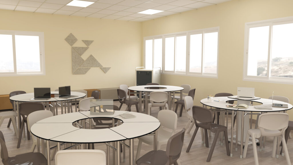 Une salle de classe Aula Mentor lumineuse au CEPA avec des tables rondes et des chaises grises, des ordinateurs portables et des livres sur les tables, de grandes fenêtres laissant entrer la lumière naturelle, et un art mural géométrique sur un mur de couleur crème.