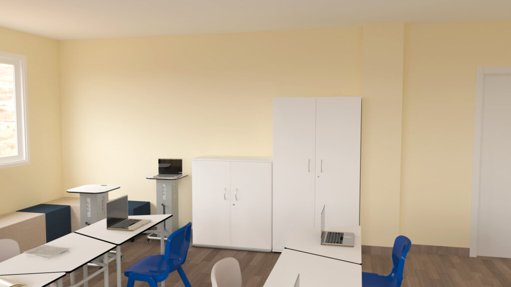 Une salle de classe avec des murs jaune clair, des armoires blanches, des chaises bleues et des bureaux blancs avec des ordinateurs portables - conçue comme un espace Aula Mentor au CEPA. La lumière naturelle pénètre par la fenêtre sur le sol en bois, les petites tables et les meubles de rangement.