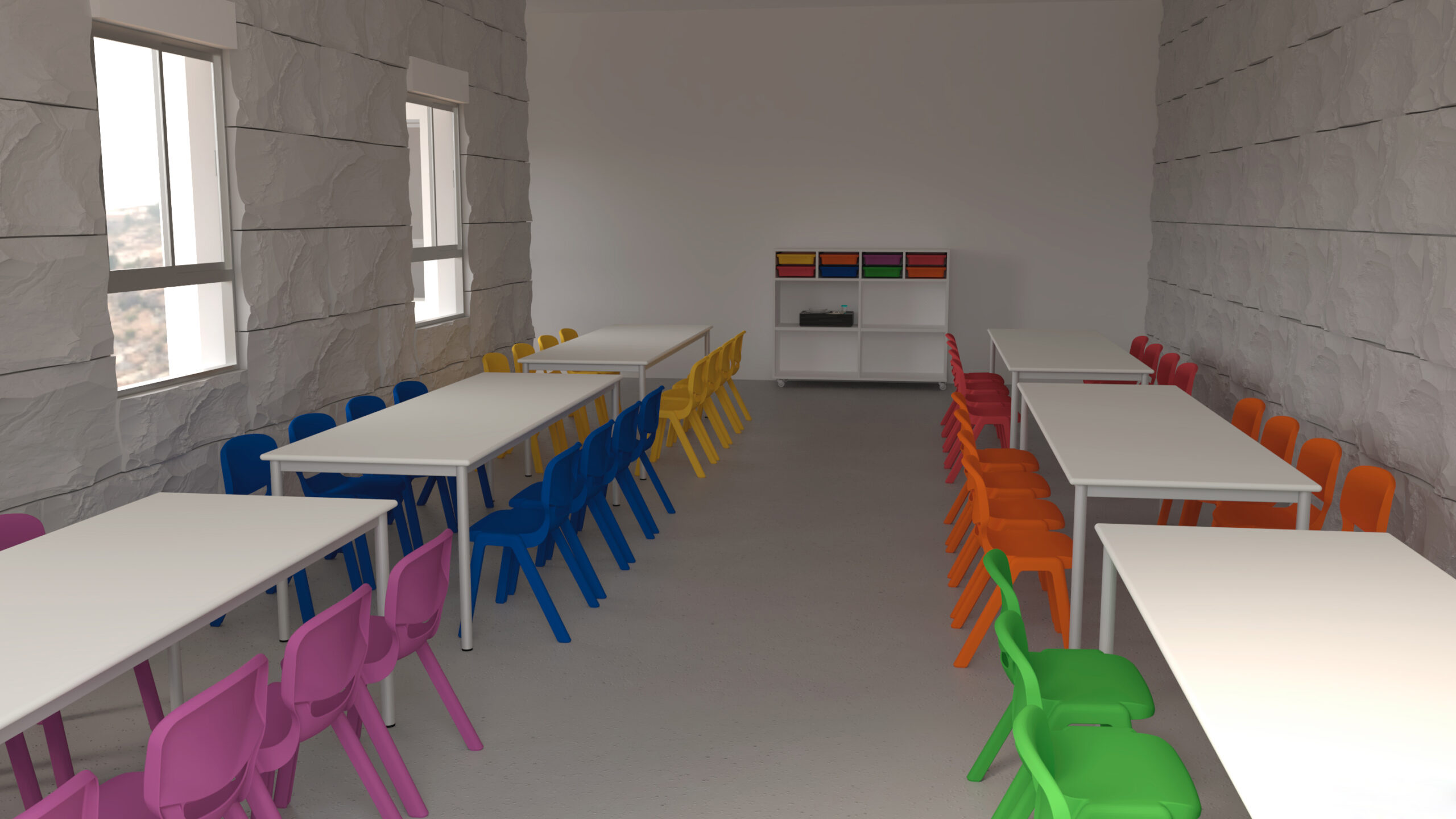 Une salle de classe avec des tables blanches et des chaises colorées - rose, bleu, jaune, orange, rouge et vert - alignées des deux côtés. Il y a des fenêtres sur la gauche et une étagère avec des boîtes au fond de la pièce.