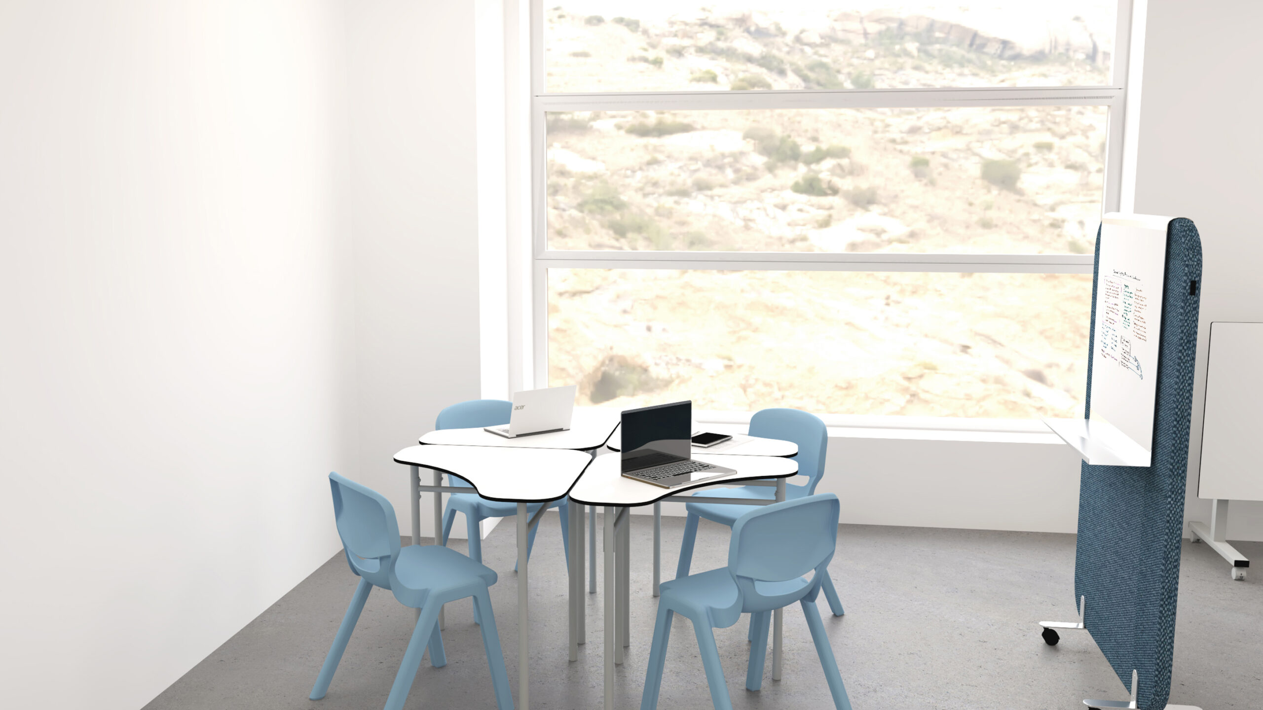 Une petite salle de réunion moderne de l'Aula Mentor Ateca comprend quatre chaises bleues autour d'une table blanche en forme de trèfle, deux ordinateurs portables, une grande fenêtre avec vue sur le désert et un tableau blanc mobile à proximité.