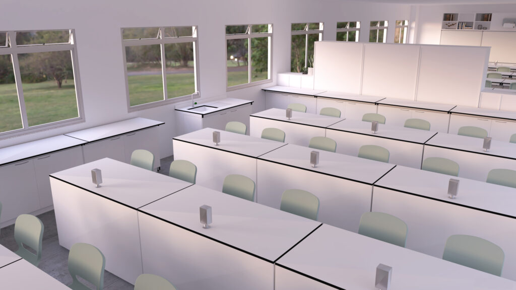 Une salle de classe moderne et vide, avec des bureaux blancs disposés en rangées, des chaises vert pâle et de grandes fenêtres laissant entrer la lumière naturelle. L'espace ressemble aux laboratoires contemporains, avec de petits appareils cubiques sur chaque bureau. La salle semble propre et organisée.
