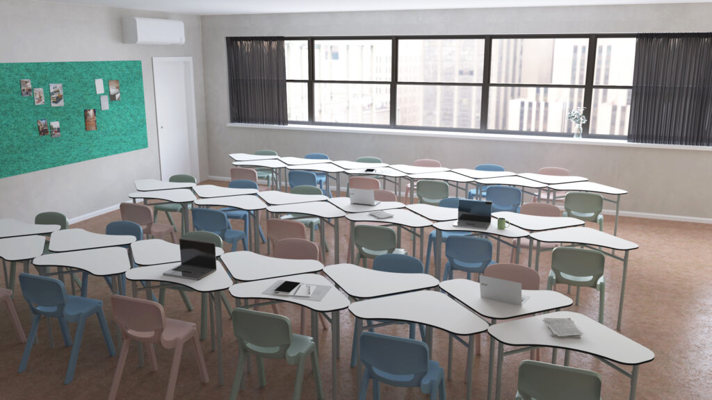 Une salle de classe moderne de l'école numérique avec des chaises de couleur pastel et des bureaux blancs incurvés disposés en rangées ; certains bureaux sont équipés d'ordinateurs portables et de cahiers ouverts. De grandes fenêtres laissent entrer la lumière naturelle et un tableau d'affichage vert est visible sur l'un des murs.