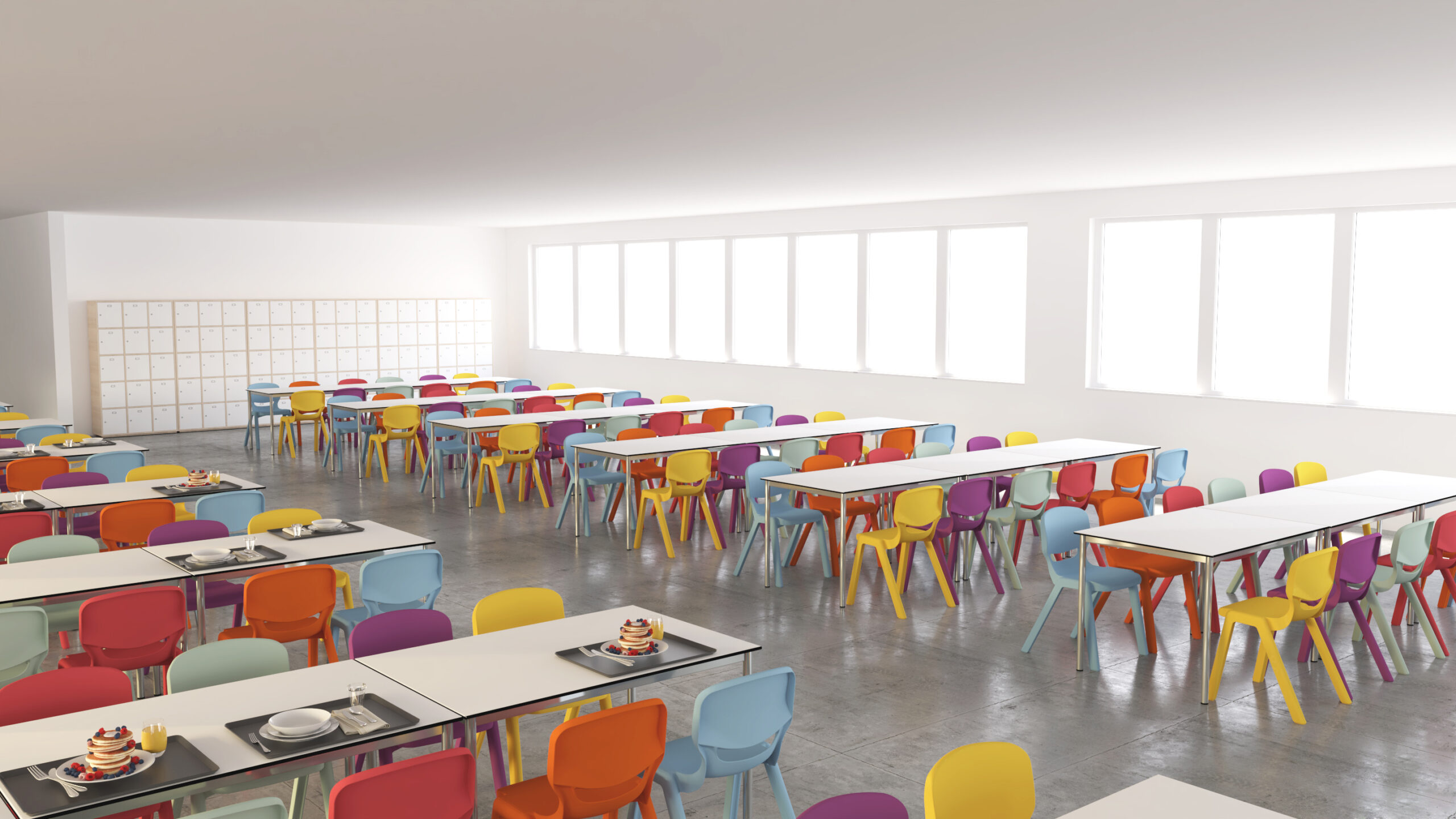 Une cafétéria d'école lumineuse avec de grandes fenêtres, des chaises colorées en rouge, jaune, bleu et violet autour de tables blanches, et quelques plateaux avec des plats et des desserts posés sur certaines tables.