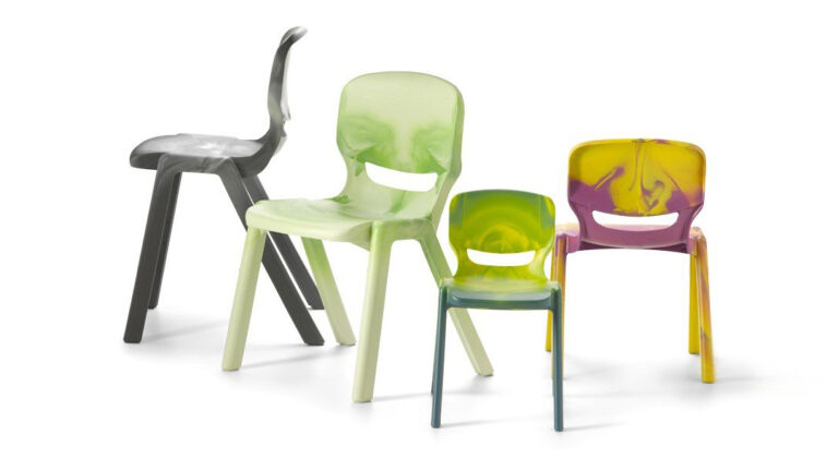 Quatre chaises colorées en plastique Ergos Special One, dont les dossiers sont ornés de visages souriants, sont disposées ensemble. Les chaises marbrées présentent des nuances de noir, de vert, de jaune, de violet et de bleu sur un fond blanc.